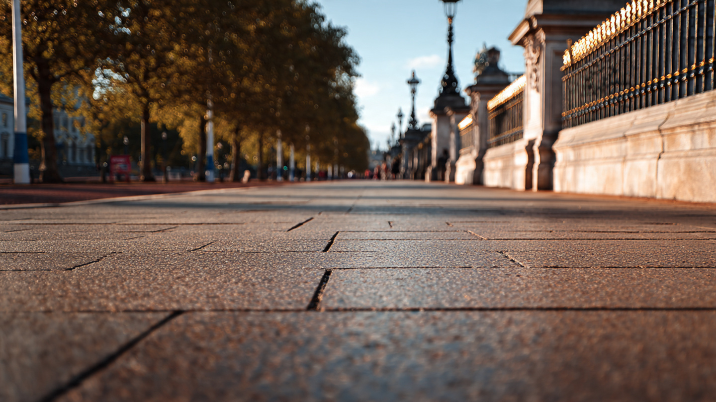 Low-angle view of the paved walkway and ornate railings near Buckingham Palace, capturing scenic walking routes and iconic surroundings as part of the best things to do near Buckingham Palace and nearby London attractions.