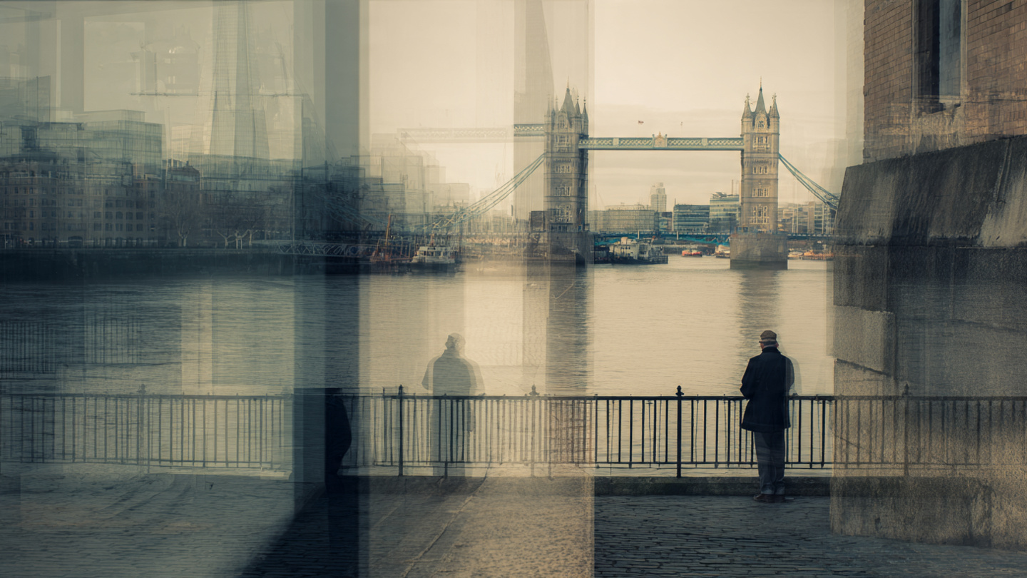 Reflective view of Tower Bridge across the Thames with a quiet riverside observer, capturing thoughtful things to do near Tower Bridge such as scenic sightseeing, peaceful walks, and riverfront exploration in London