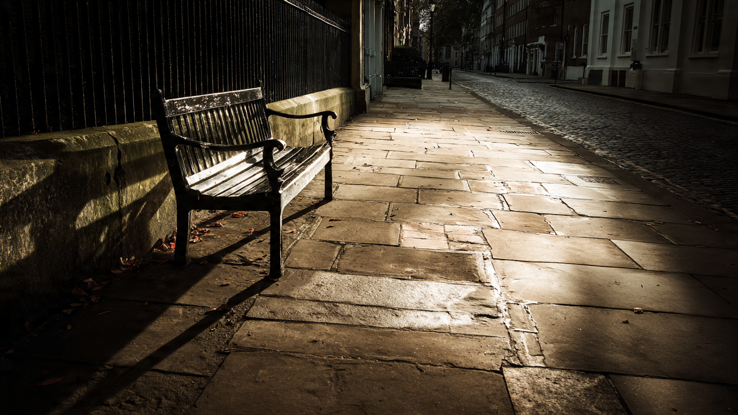 Quiet historic London pavement with an empty bench and aged stone slabs, reflecting hidden historical sites in London and overlooked heritage spaces that reveal the city’s past