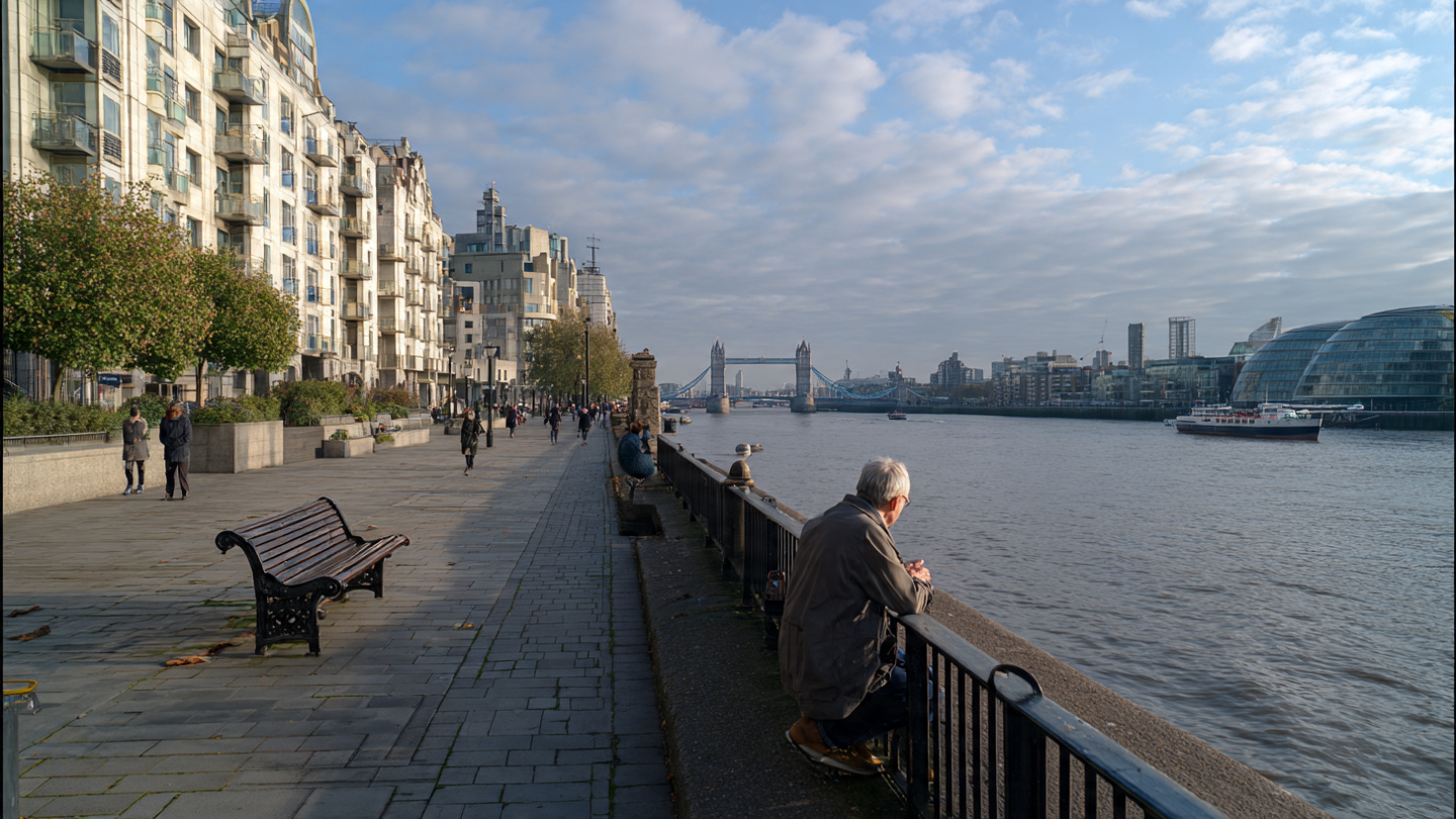 Riverside promenade near Tower Bridge with people enjoying Thames views, showing popular things to do near Tower Bridge such as scenic walking, sightseeing, and relaxing by the river in London
