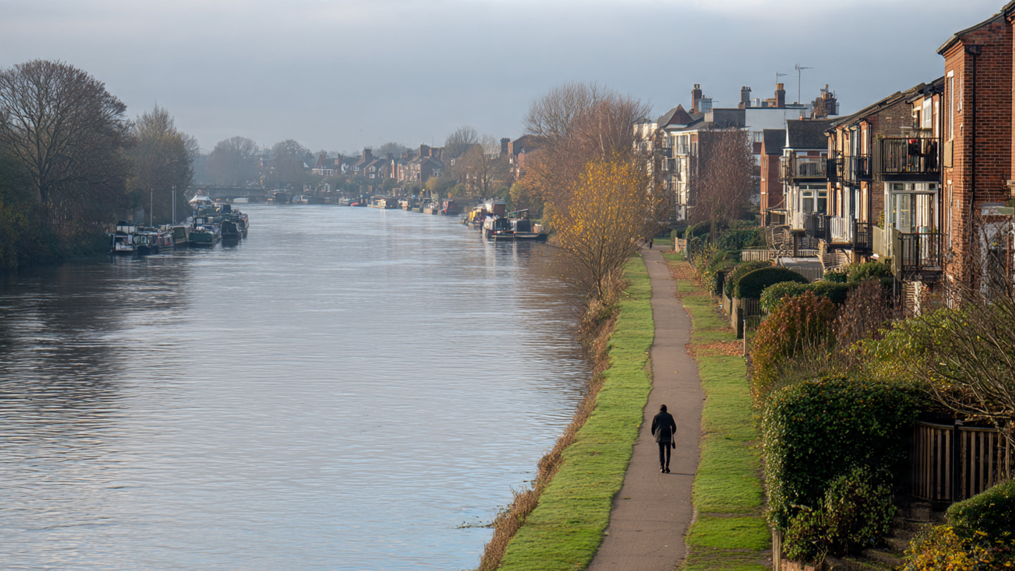 Peaceful riverside path in one of the underrated neighborhoods in London, showing quiet residential buildings and scenic waterfront views in a lesser-known London area away from busy tourist zones