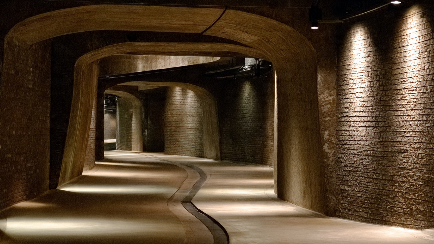 Curving underground walkway inside secret tunnels in London, showing historic subterranean corridors, hidden tunnel passages, and preserved underground architecture beneath the city streets.